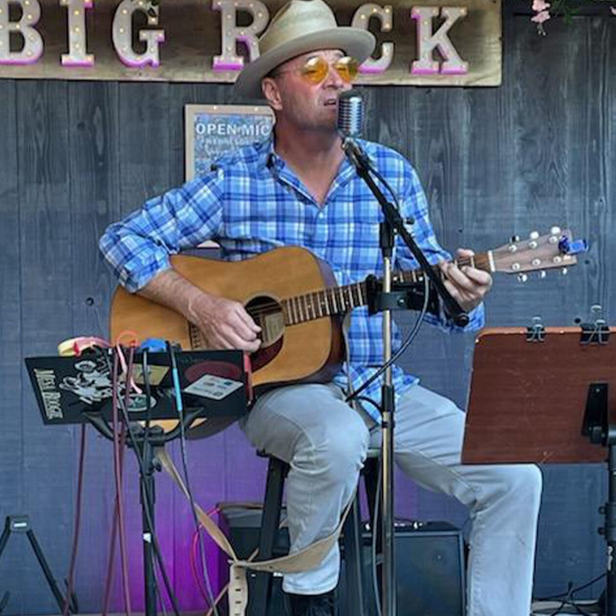 Photo of Jim Foley playing a Martin guitar on at backyard stage